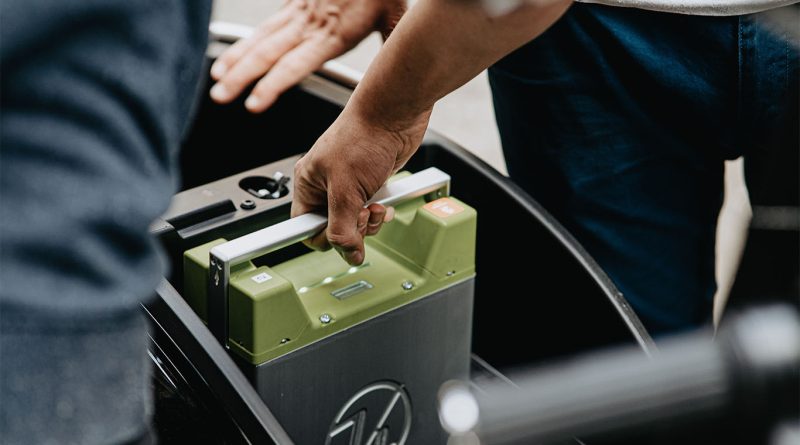Image of someone holding an electrical battery in a car to support lithium production article