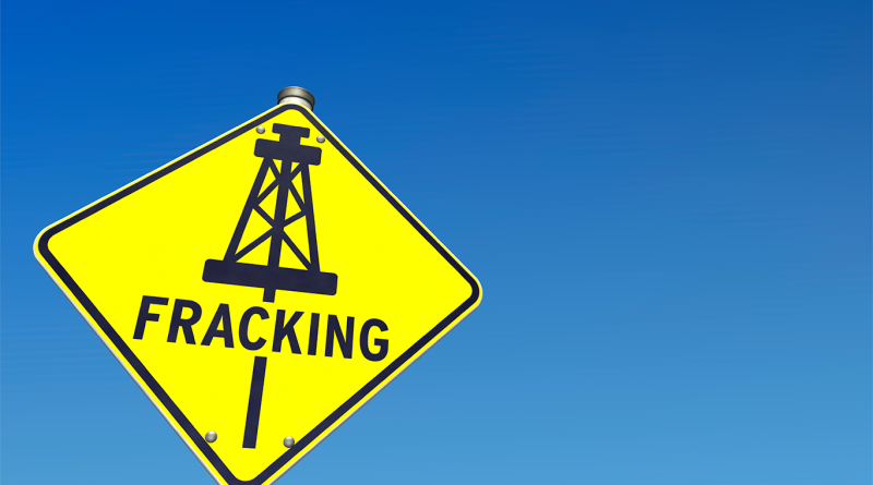 Large triangular yellow sign saying 'fracking' to support wastewater fracking article