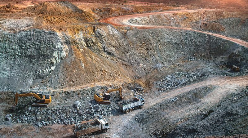 Mining crew at a gold exploration site in West Africa with excavators and core samples