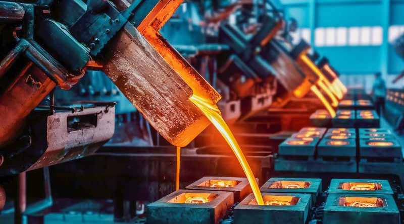 Molten copper is poured from an industrial ladle into rectangular molds on a production line at a smelter.