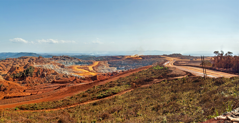 Open pit mine in Africa, with huge crane and trucks ro bring ore to a processing plant